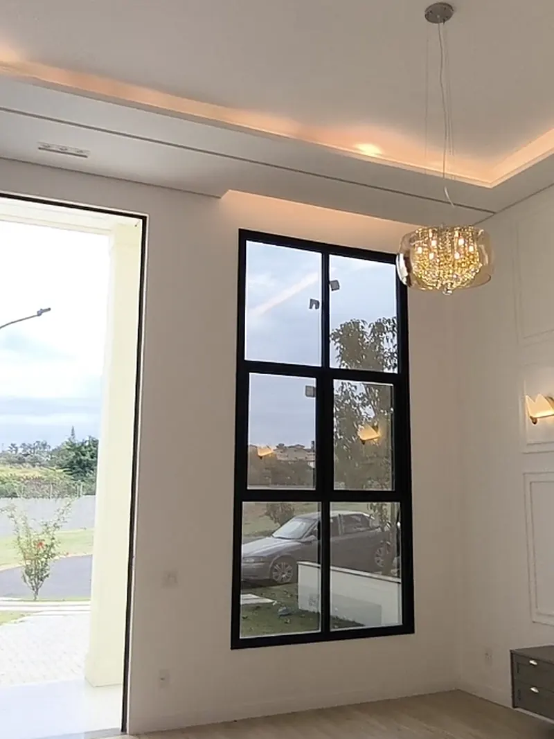 Hall de entrada com pé-direito alto e janela de caixilho preto